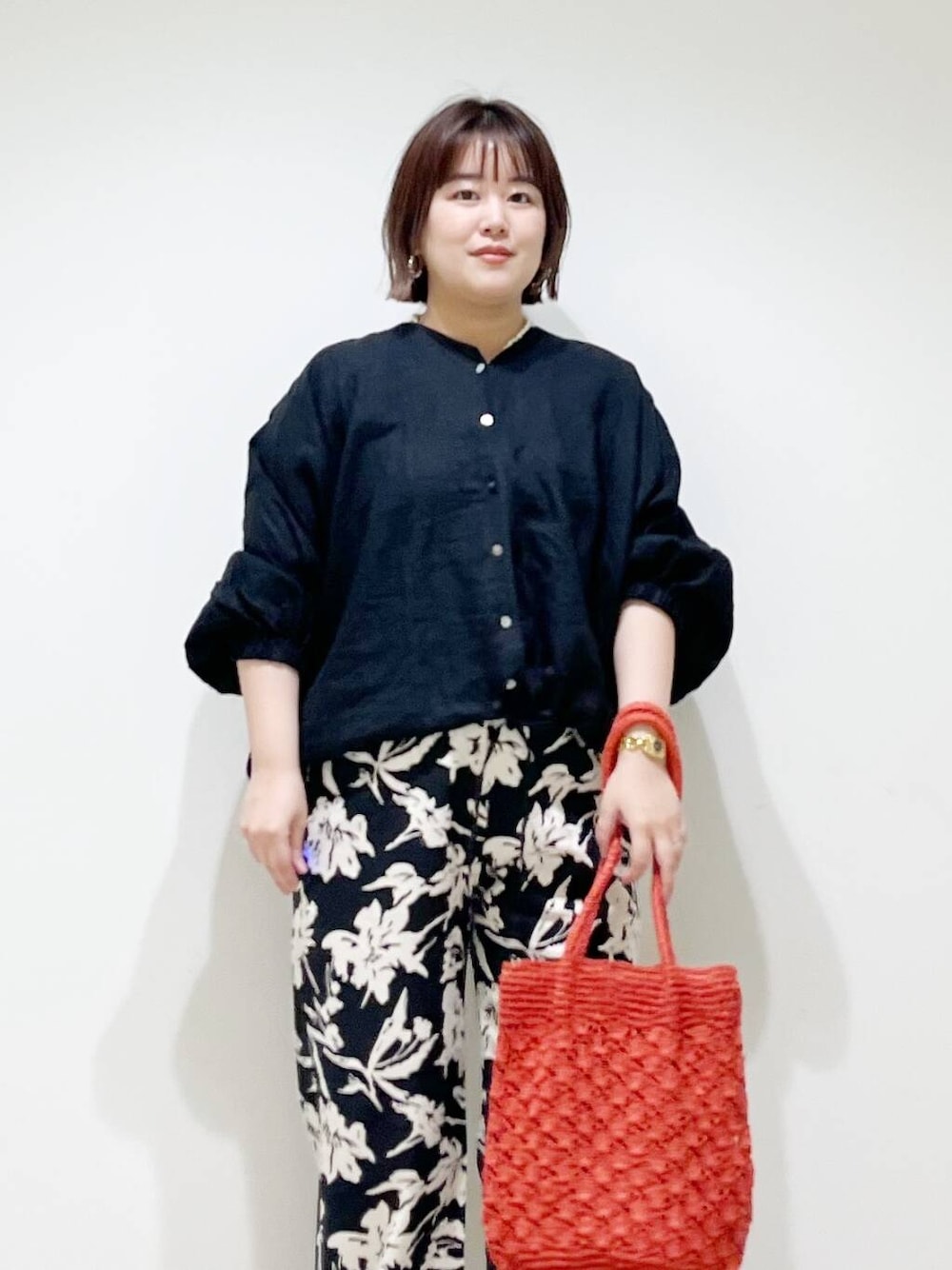 シルバー系のパンプス、ブラック系のその他パンツ、オレンジ系のトートバッグを着用したレディースの春コーディネートの3枚目の写真