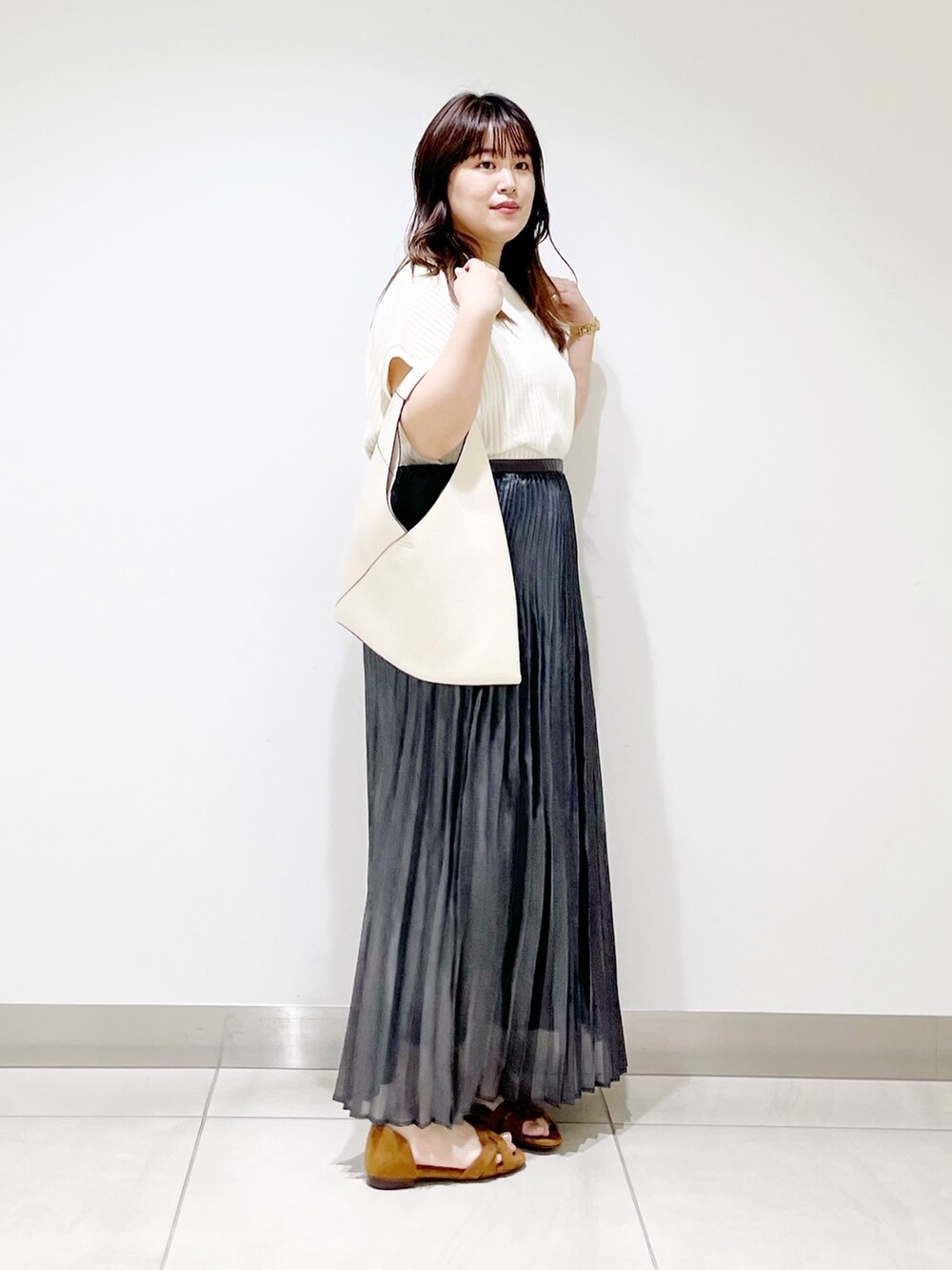 ホワイト系のニット/セーター、ホワイト系のトートバッグ、ブラック系のスカートを着用したレディースの夏コーディネートの6枚目の写真