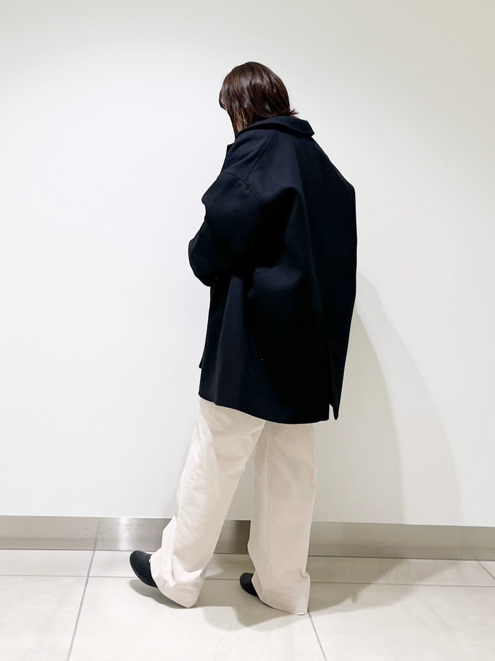 ブルー系のピーコート、ブラック系のニット/セーター、ホワイト系のTシャツ/カットソーを着用したレディースの冬コーディネートの6枚目の写真