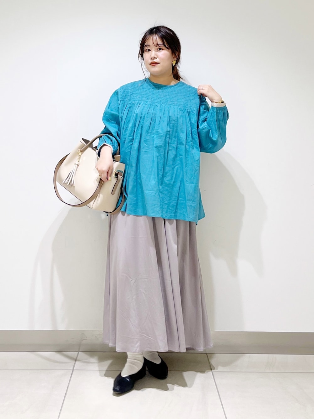 ブルー系のシャツ/ブラウス、グレー系のスカート、ホワイト系のトートバッグを着用したレディースの春コーディネートの5枚目の写真