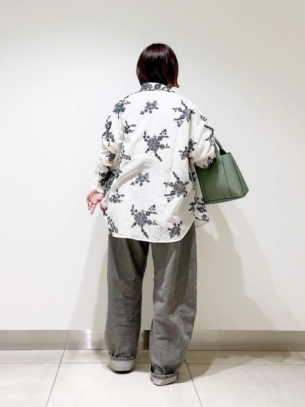 グリーン系のデニムパンツ、グリーン系のトートバッグ、シルバー系のパンプスを着用したレディースの春コーディネートの7枚目の写真