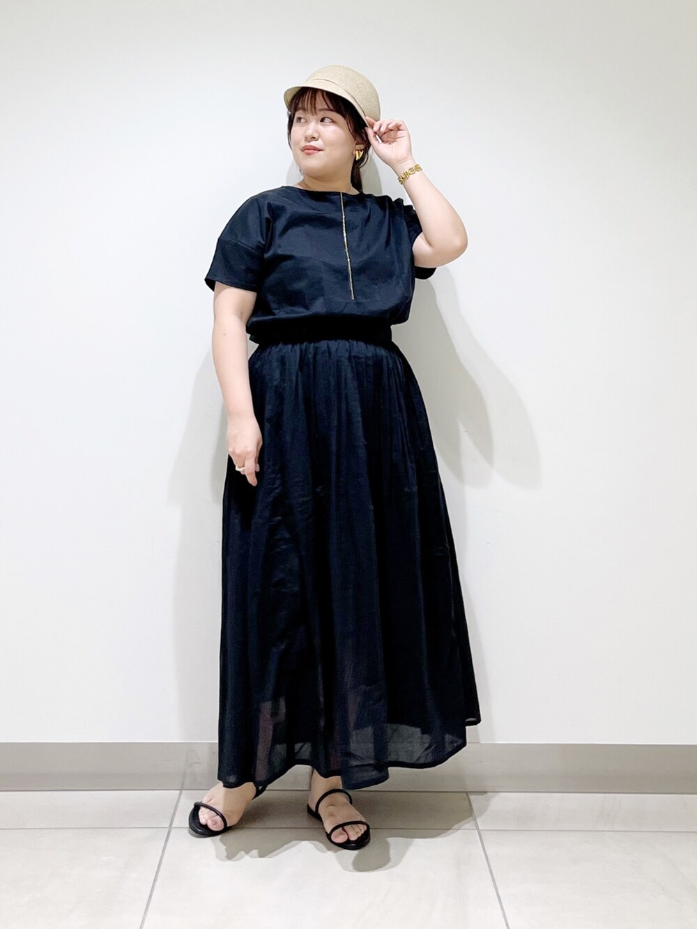 ブラック系のワンピース、ブラック系のサンダル、ベージュ系のキャスケットを着用したレディースの夏コーディネートの10枚目の写真