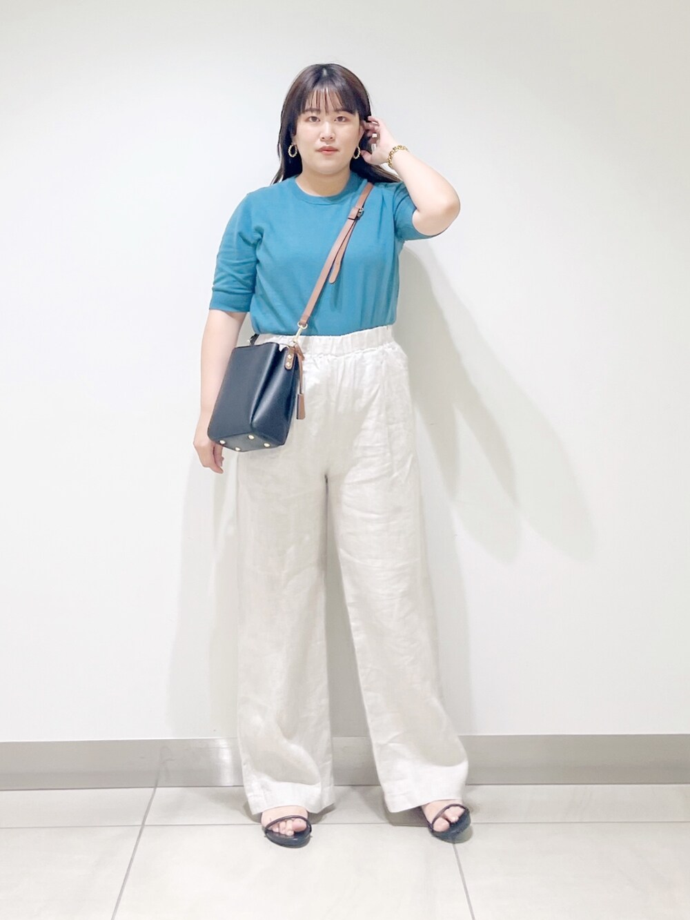 ブルー系のニット/セーター、ベージュ系のその他パンツ、ブラック系のショルダーバッグを着用したレディースの春コーディネートの8枚目の写真