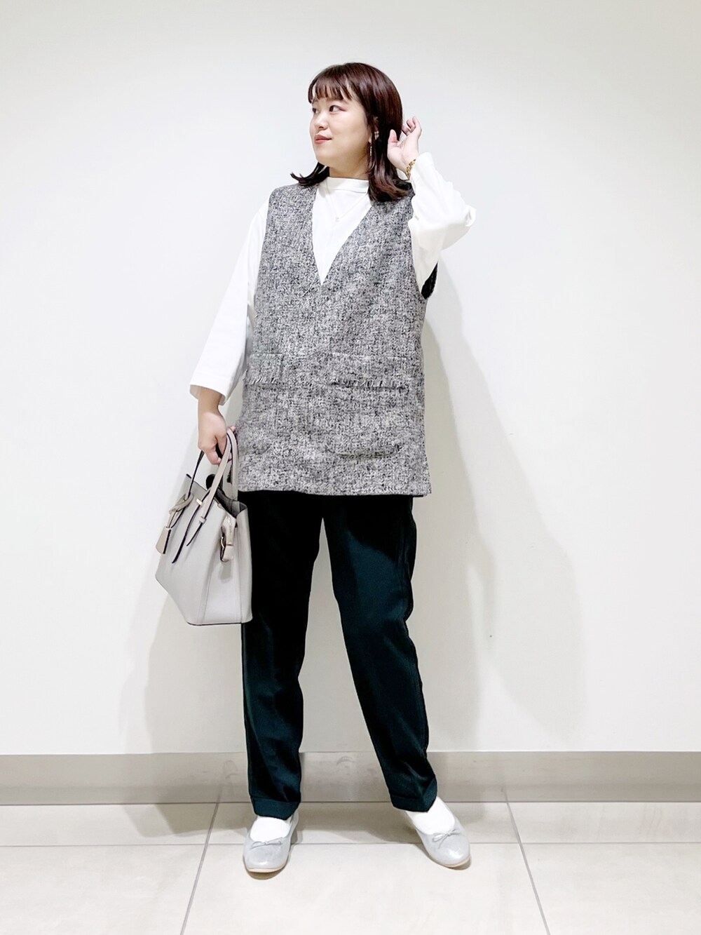 グレー系のトップス、グリーン系のパンツ、グレー系のトートバッグを着用したレディースの夏コーディネートの2枚目の写真