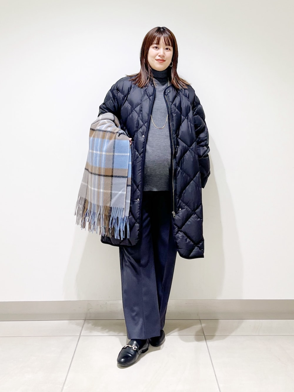 ブラック系のダウンジャケット/コート、グレー系のニット/セーター、グレー系のその他パンツを着用したレディースの冬コーディネートの8枚目の写真