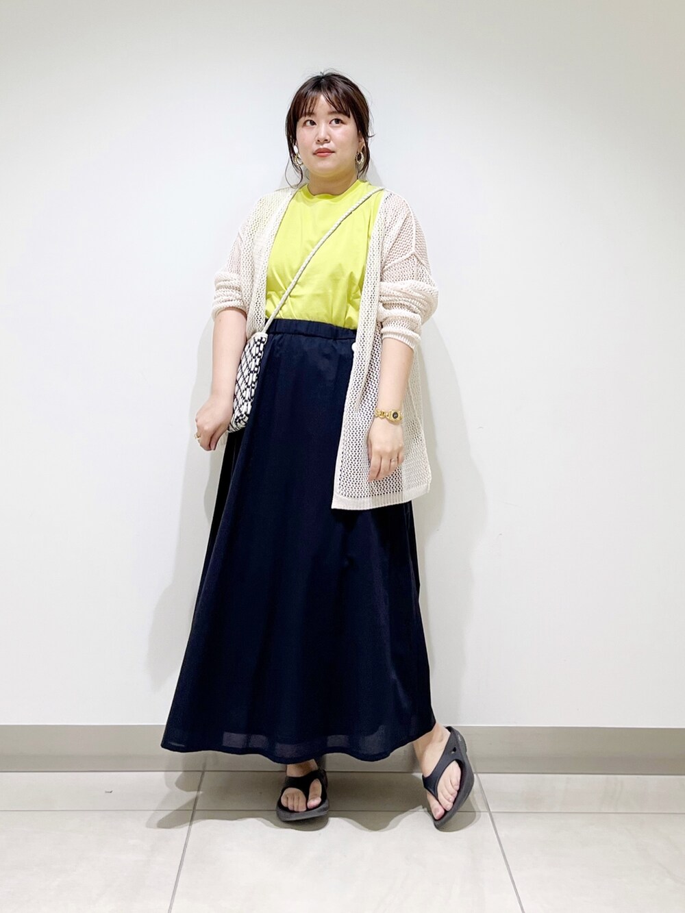 ホワイト系のカーディガン/ボレロ、ブラック系のショルダーバッグ、ブルー系のスカートを着用したレディースの春コーディネートの6枚目の写真