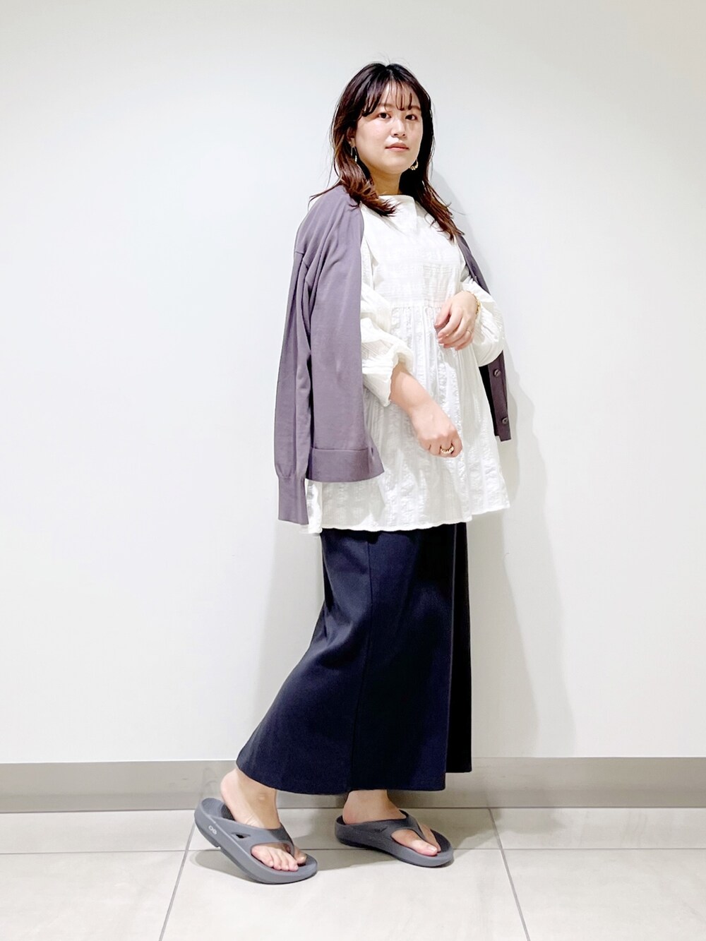 ホワイト系のシャツ/ブラウス、グレー系のカーディガン/ボレロ、グレー系のスカートを着用したレディースの春コーディネートの2枚目の写真