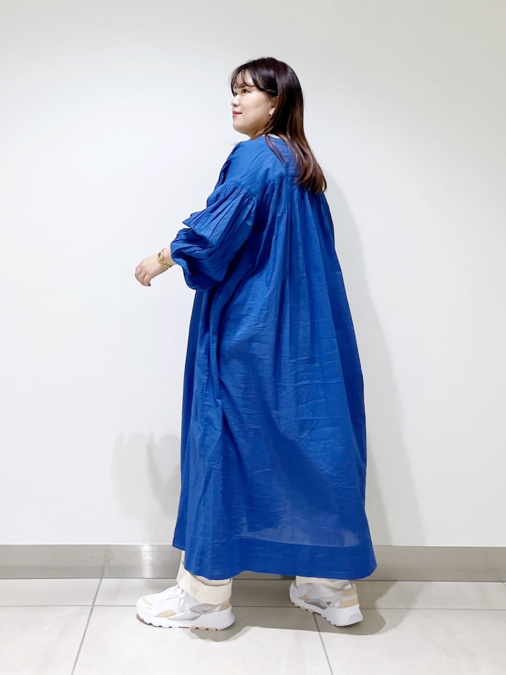 ブルー系のワンピース、ベージュ系のデニムパンツ、ベージュ系のTシャツ/カットソーを着用したレディースの春コーディネートの3枚目の写真