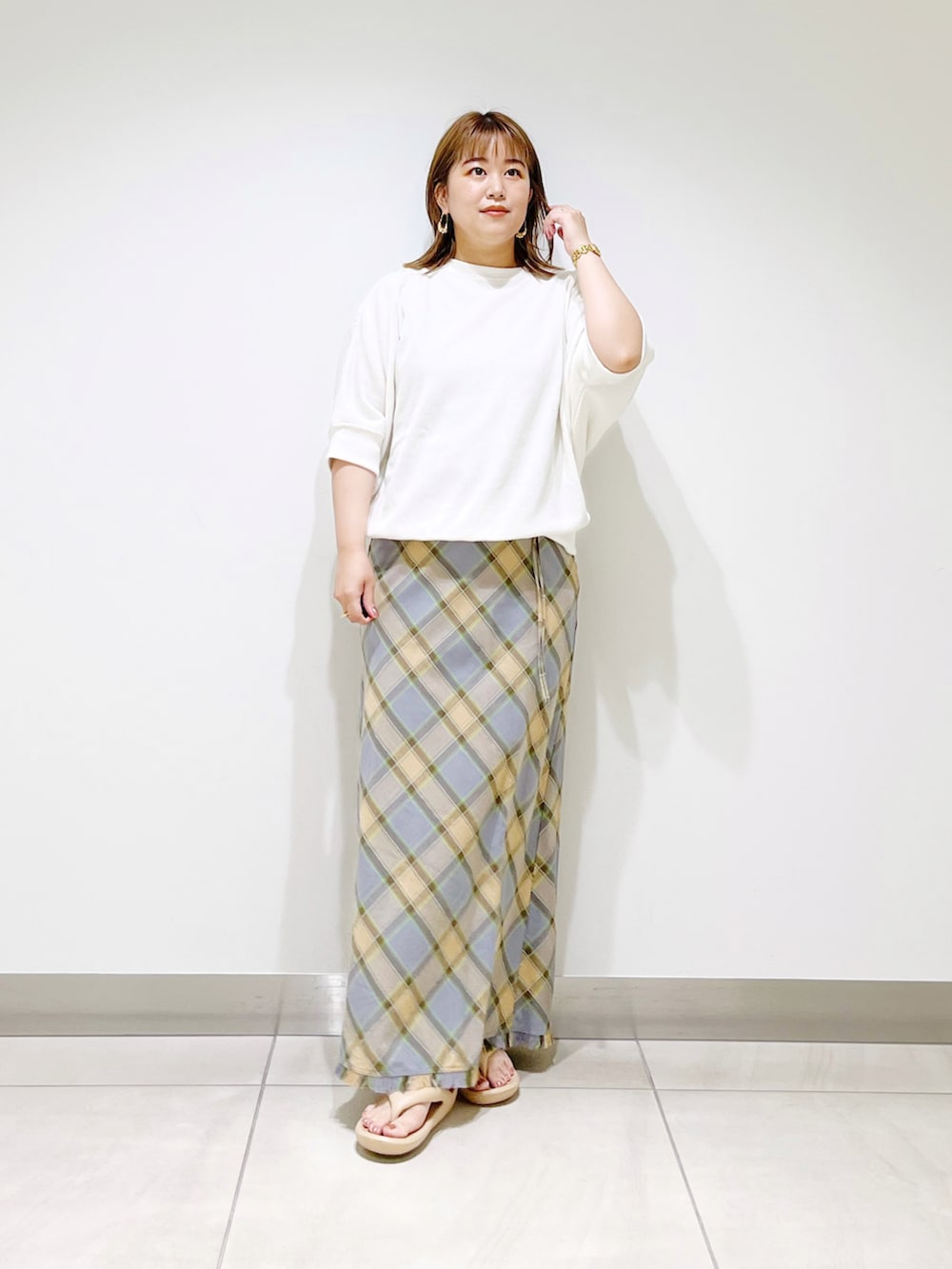 ホワイト系のTシャツ/カットソー、グレー系のスカート、ベージュ系のサンダルを着用したレディースの夏コーディネートの2枚目の写真