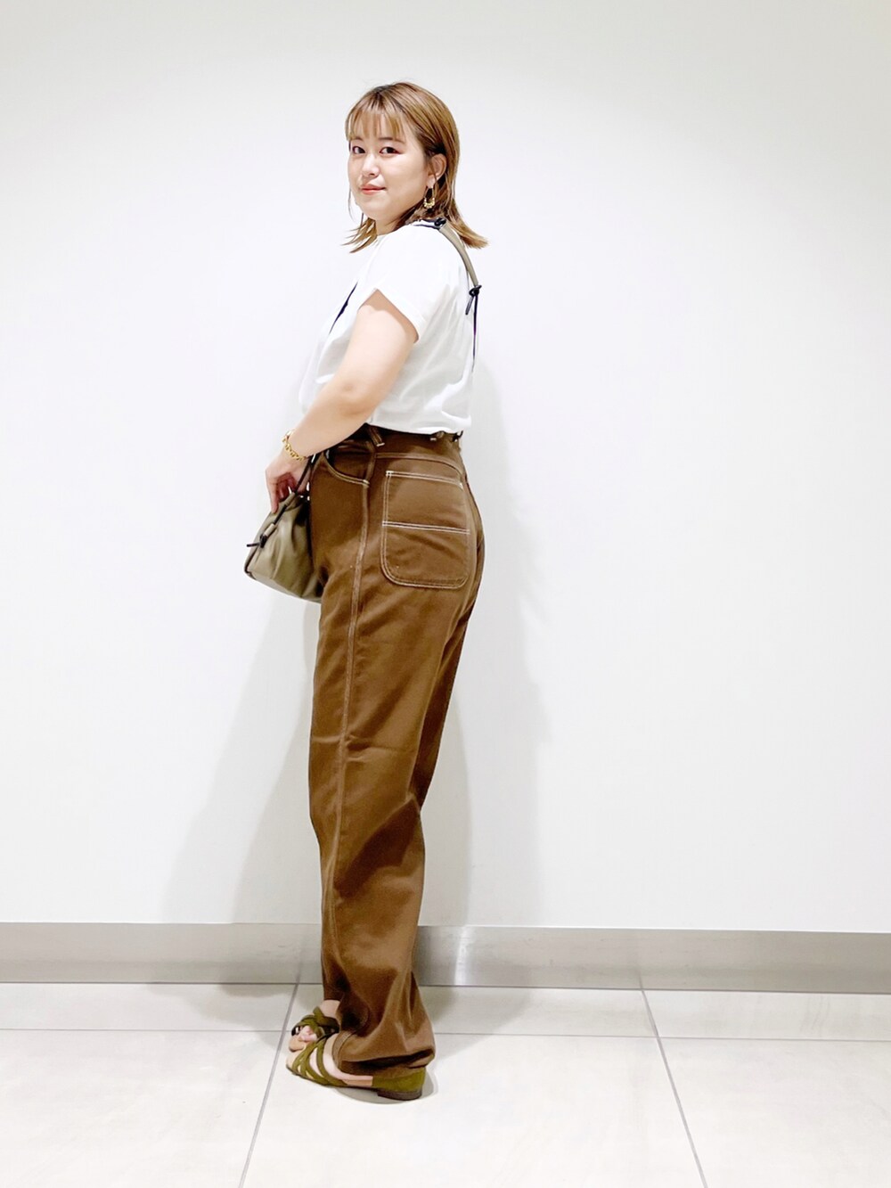 ホワイト系のTシャツ/カットソー、ブラウン系のその他パンツ、ベージュ系のショルダーバッグを着用したレディースの夏コーディネートの2枚目の写真