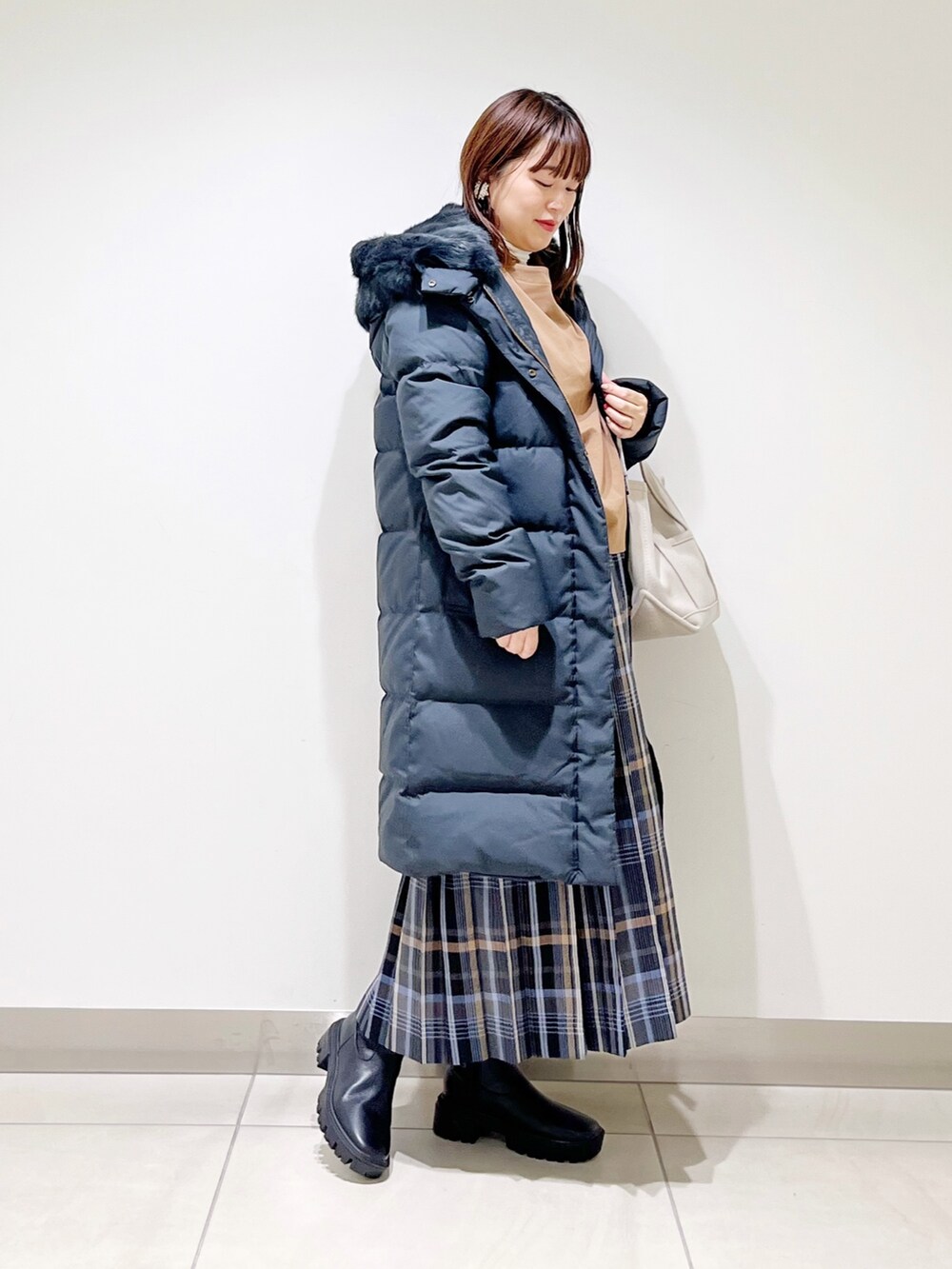 イエロー系のTシャツ/カットソー、ブラック系のダウンジャケット/コート、ブルー系のスカートを着用したレディースの秋コーディネートの8枚目の写真