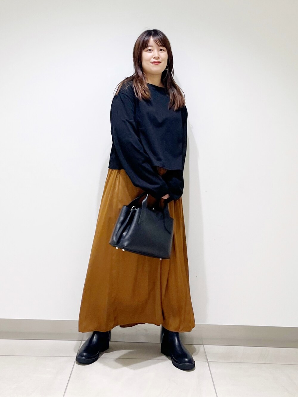 ブラック系のTシャツ/カットソー、イエロー系のパンツ、ブラック系のハンドバッグを着用したレディースの夏コーディネートの2枚目の写真