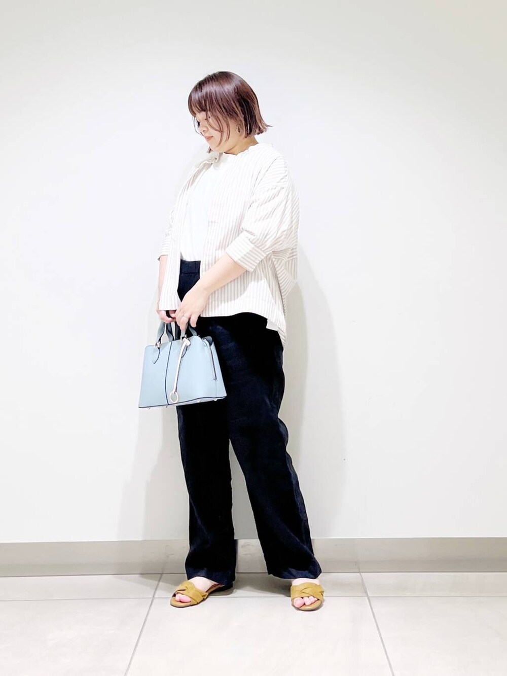 ブラック系のその他パンツ、ベージュ系のシャツ/ブラウス、イエロー系のサンダルを着用したレディースの春コーディネートの3枚目の写真