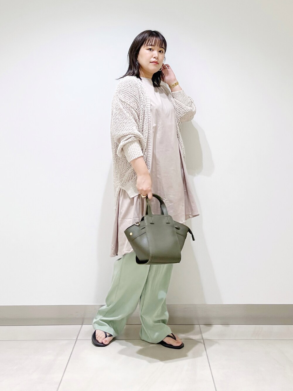 ホワイト系のカーディガン/ボレロ、ベージュ系のTシャツ/カットソー、グリーン系のハンドバッグを着用したレディースの夏コーディネートの3枚目の写真