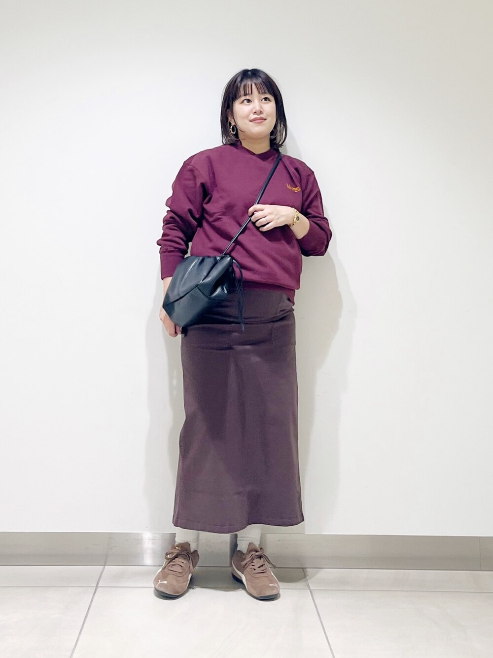 ブラウン系のスウェット、ブラウン系のスカート、ブラック系のスニーカーを着用したレディースの秋コーディネートの6枚目の写真