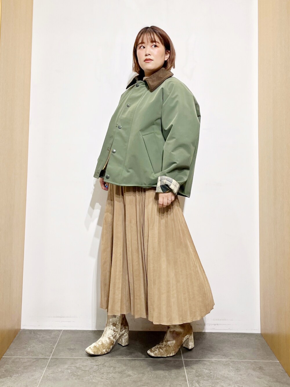 グリーン系のその他アウター、ホワイト系のニット/セーター、イエロー系のスカートを着用したレディースの秋コーディネートの3枚目の写真