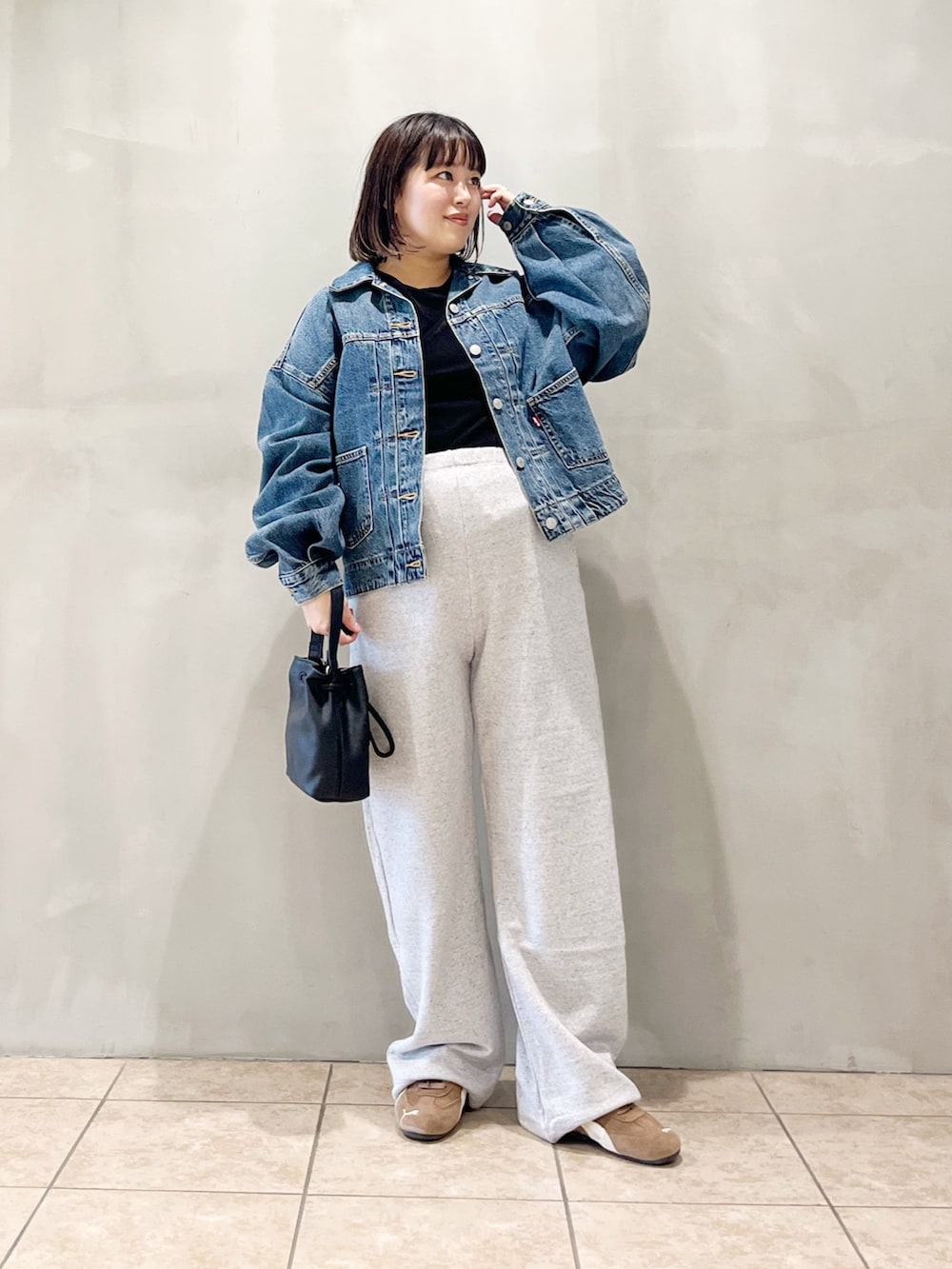 ブルー系のデニムジャケット、ブラック系のスニーカー、グレー系のその他パンツを着用したレディースの秋コーディネートの9枚目の写真