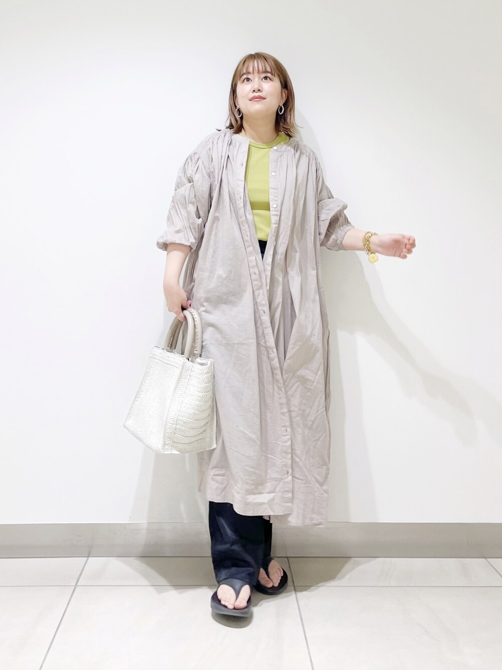 グレー系のワンピース、ホワイト系のトートバッグ、グリーン系のTシャツ/カットソーを着用したレディースの春コーディネートの4枚目の写真