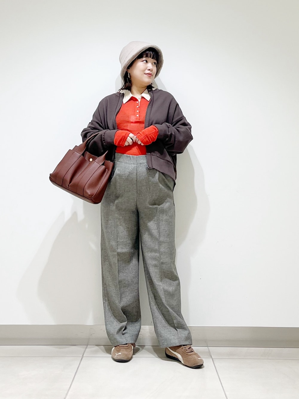 レッド系のニット/セーター、グレー系のその他パンツ、ブラック系のスニーカーを着用したレディースの秋コーディネートの5枚目の写真