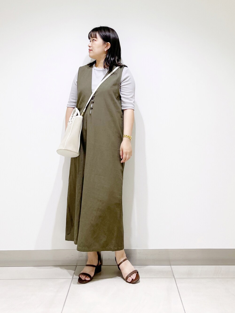 グレー系のワンピース、ベージュ系のショルダーバッグ、ブラック系のサンダルを着用したレディースの夏コーディネートの2枚目の写真