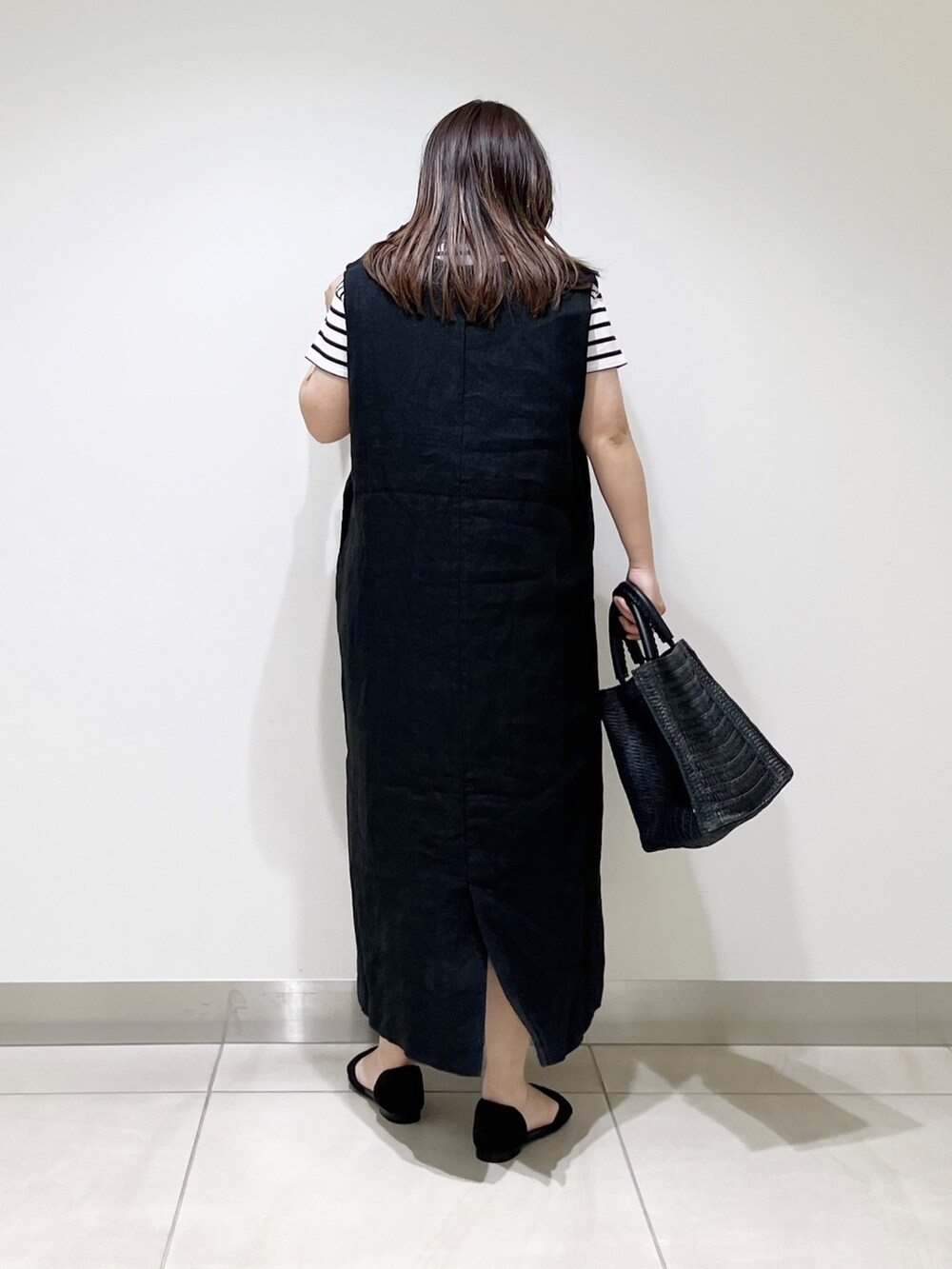 ブラック系のワンピース、ブラック系のTシャツ/カットソー、ブラック系のバッグを着用したレディースの春コーディネートの3枚目の写真