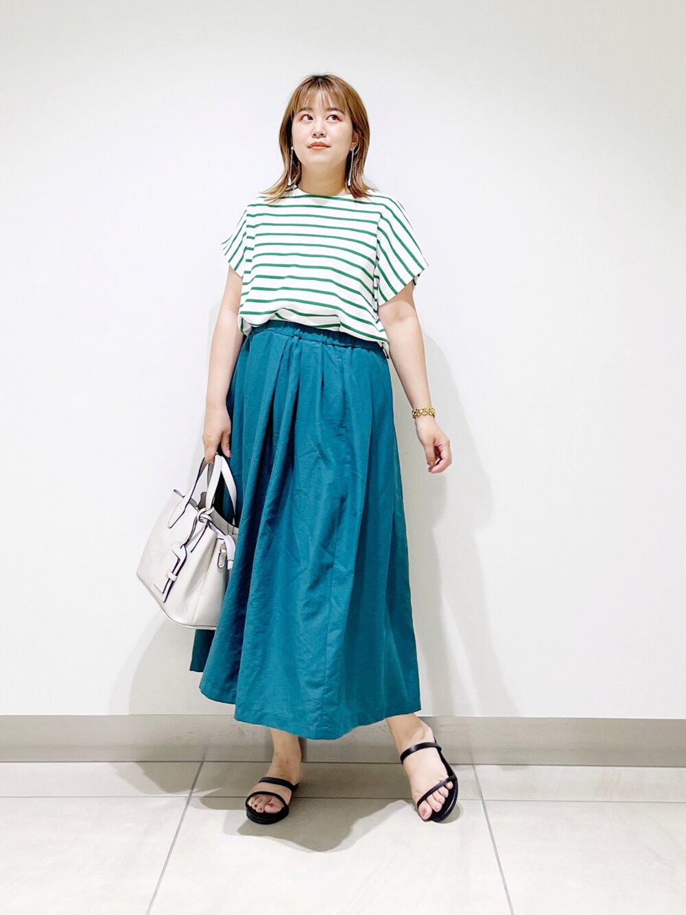 グリーン系のTシャツ/カットソー、グリーン系のスカート、グレー系のトートバッグを着用したレディースの夏コーディネートの3枚目の写真