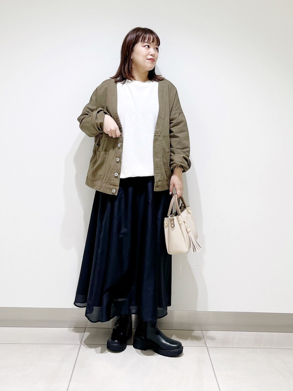 ホワイト系のTシャツ/カットソー、グリーン系のジャケット/アウター、ブラック系のスカートを着用したレディースの夏コーディネートの6枚目の写真