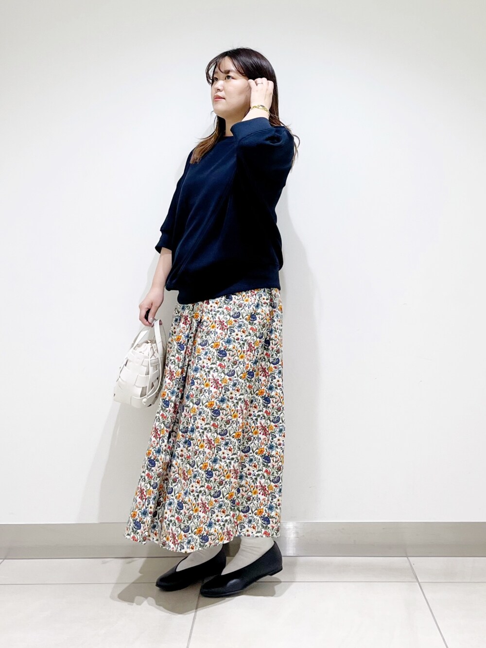 ブルー系のTシャツ/カットソー、ホワイト系のスカート、ホワイト系のショルダーバッグを着用したレディースの春コーディネートの2枚目の写真