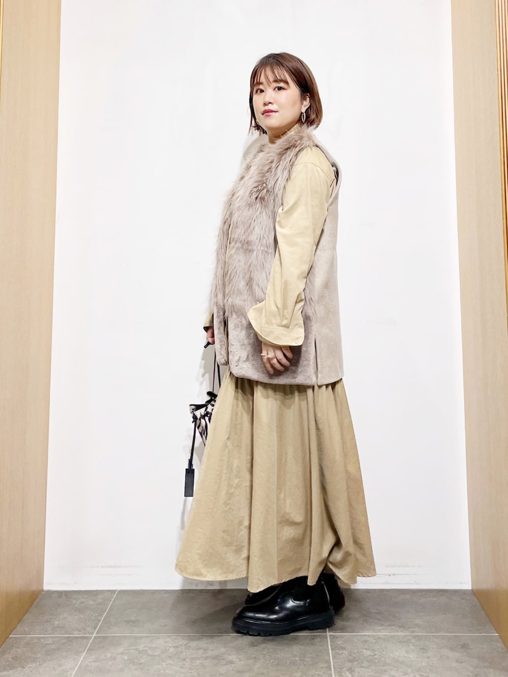 ベージュ系のベスト、ベージュ系のワンピース、その他のバッグを着用したレディースの秋コーディネートの5枚目の写真