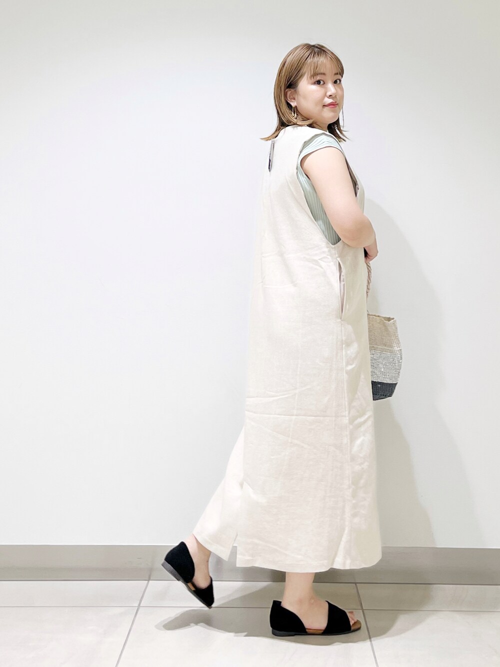 ベージュ系のワンピース、その他のハンドバッグ、ブラック系のサンダルを着用したレディースの夏コーディネートの5枚目の写真