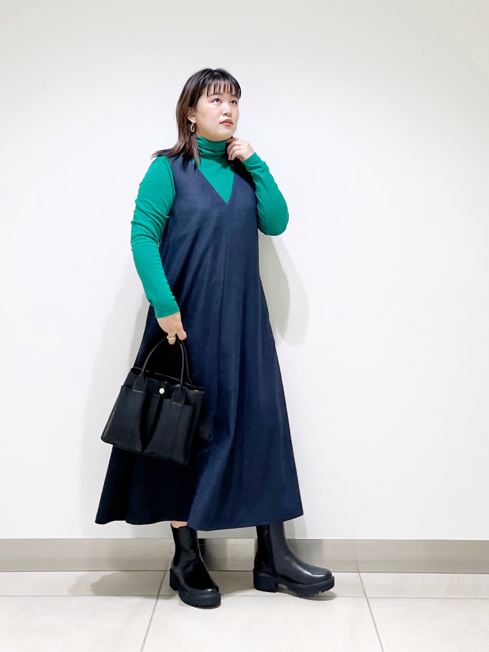 ブルー系のワンピース、ブラック系のトートバッグ、ブラック系のブーツを着用したレディースの秋コーディネートの5枚目の写真