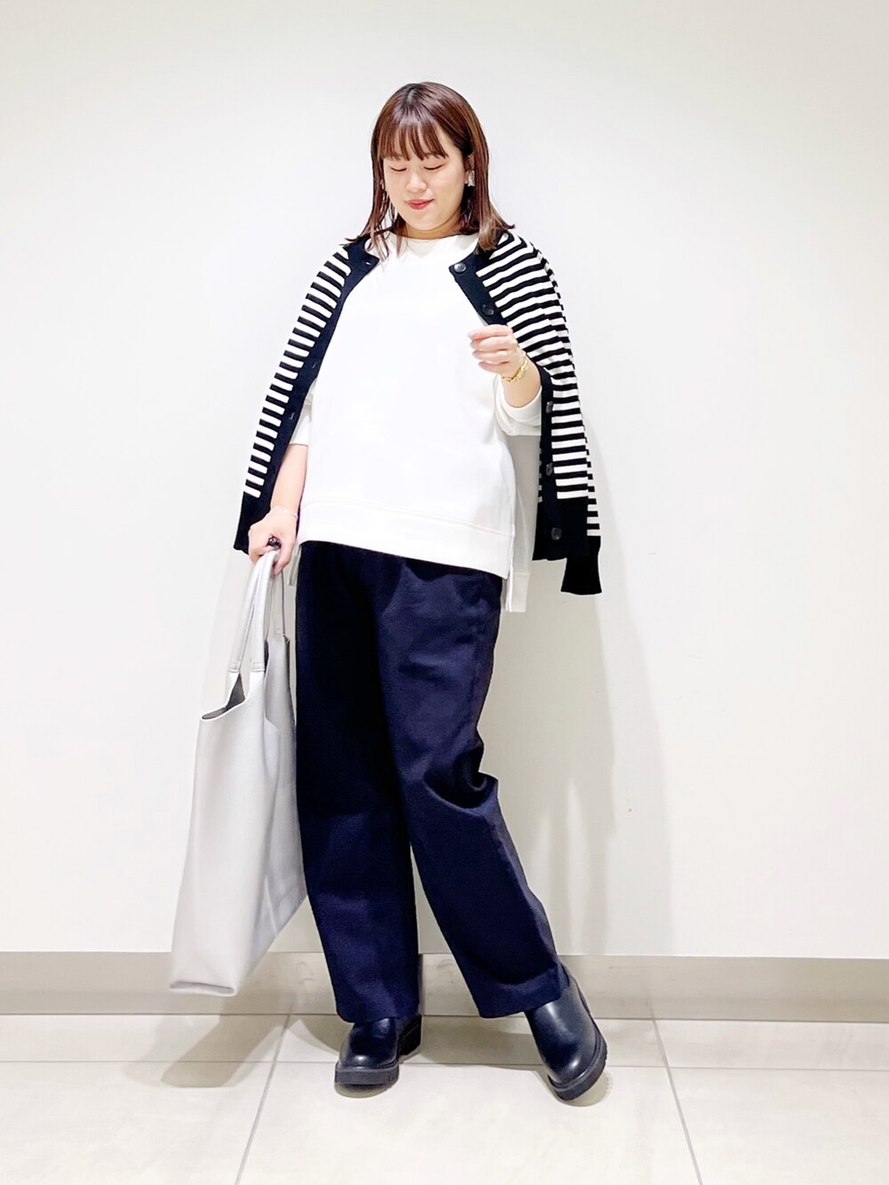 ホワイト系のTシャツ/カットソー、ブラック系のカーディガン/ボレロ、ブルー系のその他パンツを着用したレディースの秋コーディネートの9枚目の写真