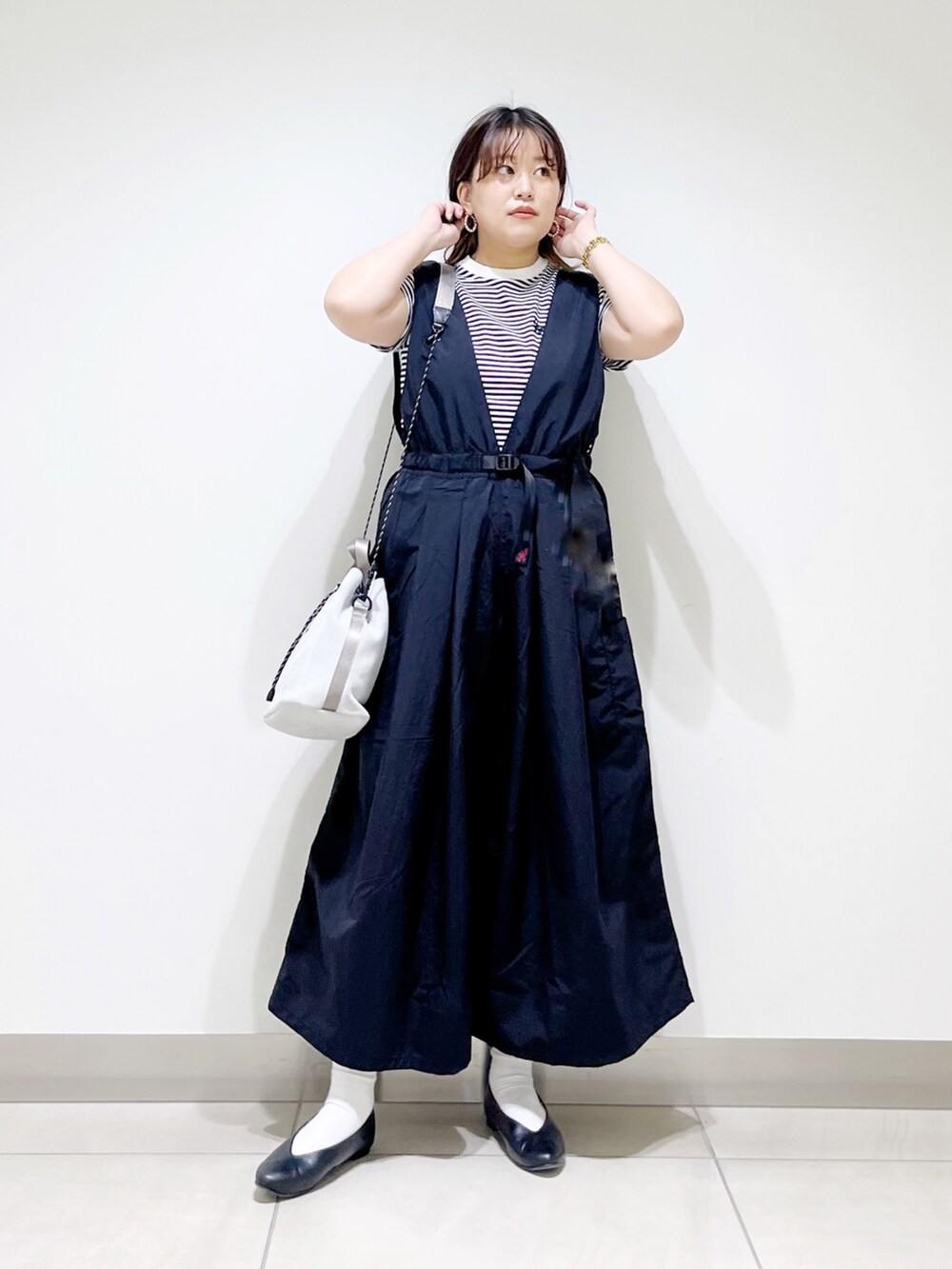 ブラック系のサロペット/オーバーオール、グレー系のTシャツ/カットソー、ホワイト系のショルダーバッグを着用したレディースの春コーディネートの3枚目の写真