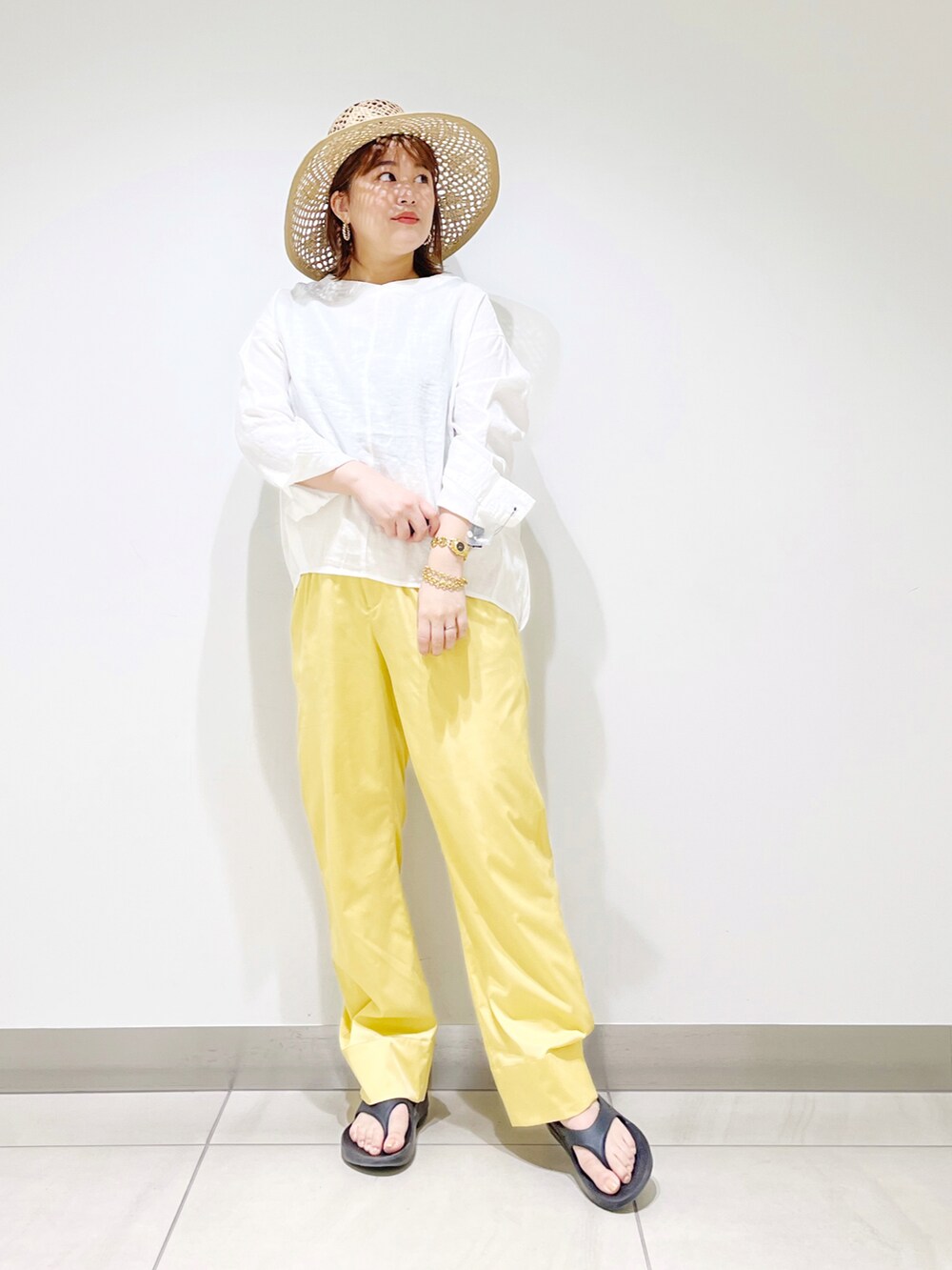 ホワイト系のシャツ/ブラウス、イエロー系のその他パンツ、ブラック系のサンダルを着用したレディースの春コーディネートの4枚目の写真