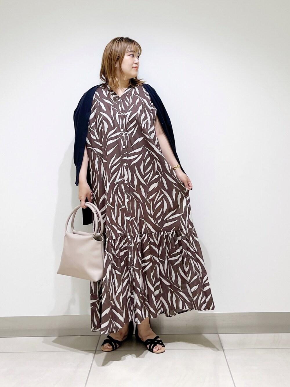ブラウン系のワンピース、ベージュ系のハンドバッグ、ブラック系のサンダルを着用したレディースの夏コーディネートの5枚目の写真