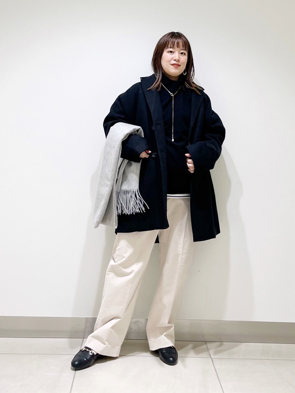 ブルー系のピーコート、ブラック系のニット/セーター、ホワイト系のTシャツ/カットソーを着用したレディースの冬コーディネートの8枚目の写真