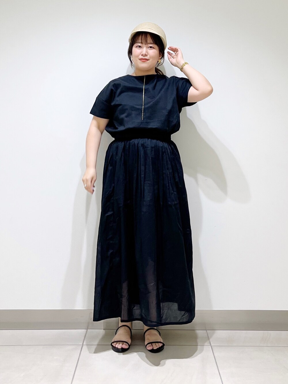 ブラック系のワンピース、ブラック系のサンダル、ベージュ系のキャスケットを着用したレディースの夏コーディネートの8枚目の写真