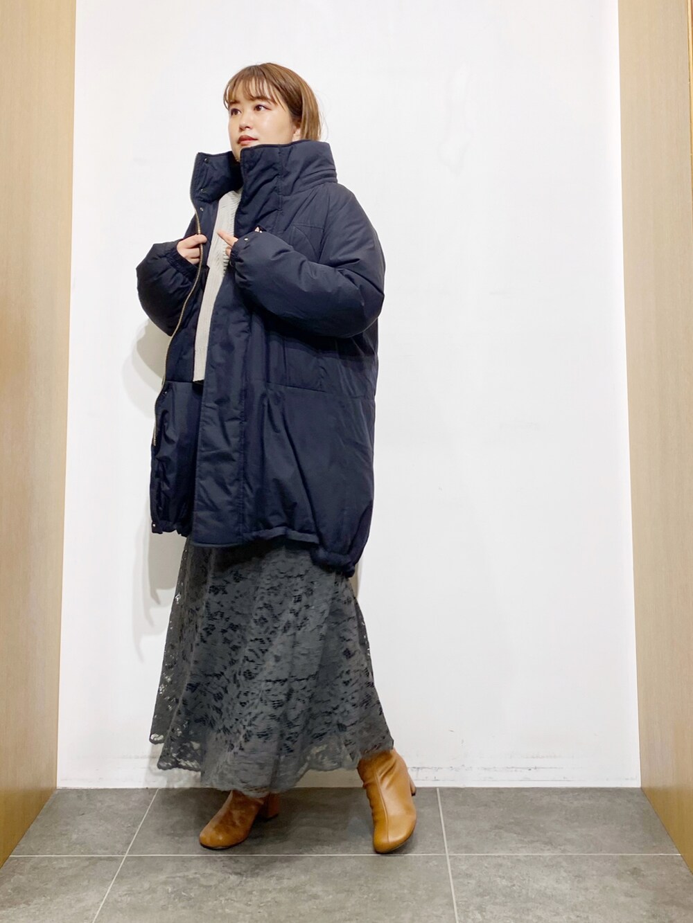 ブラック系のダウンジャケット/コート、ホワイト系のカーディガン/ボレロ、ブラウン系のTシャツ/カットソーを着用したレディースの秋コーディネートの4枚目の写真