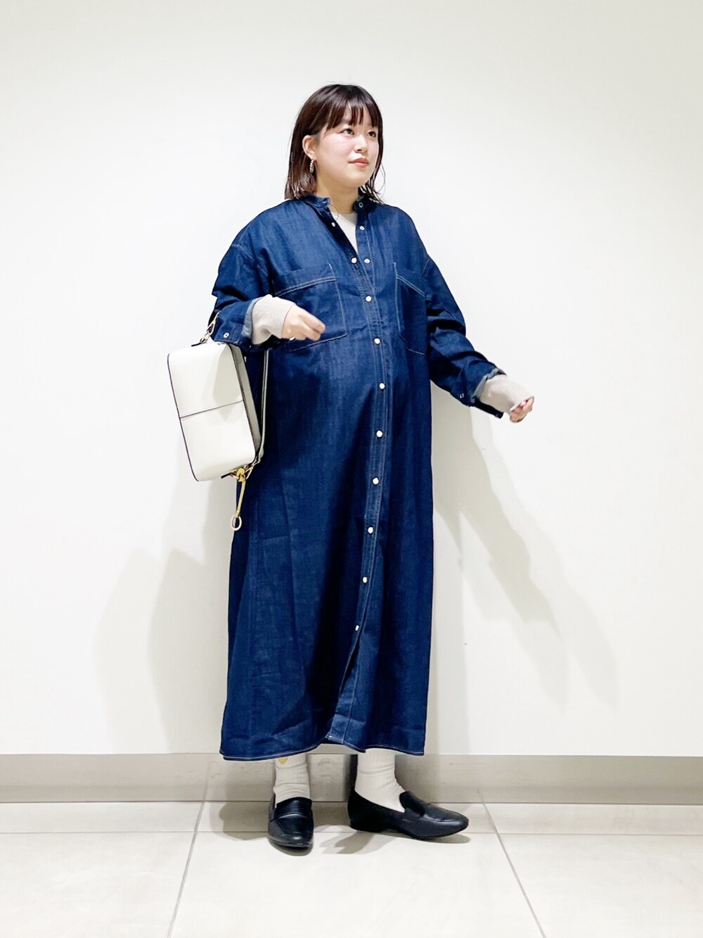 ブルー系のワンピース、ベージュ系のニット/セーター、ホワイト系のショルダーバッグを着用したレディースの秋コーディネートの9枚目の写真