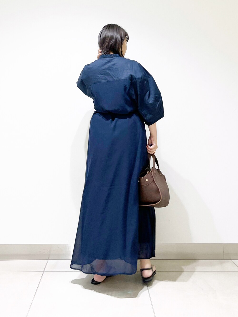 ブルー系のワンピース、ブラウン系のハンドバッグ、ブラック系のサンダルを着用したレディースの夏コーディネートの5枚目の写真