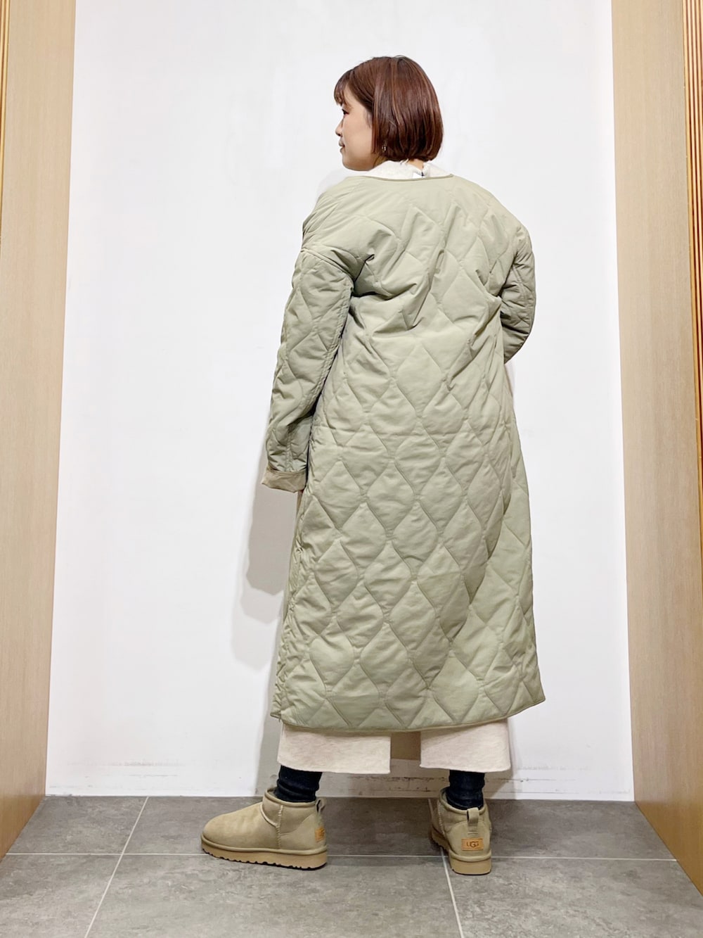 グリーン系のその他アウター、ベージュ系のスカート、グリーン系のブーツを着用したレディースの秋コーディネートの3枚目の写真