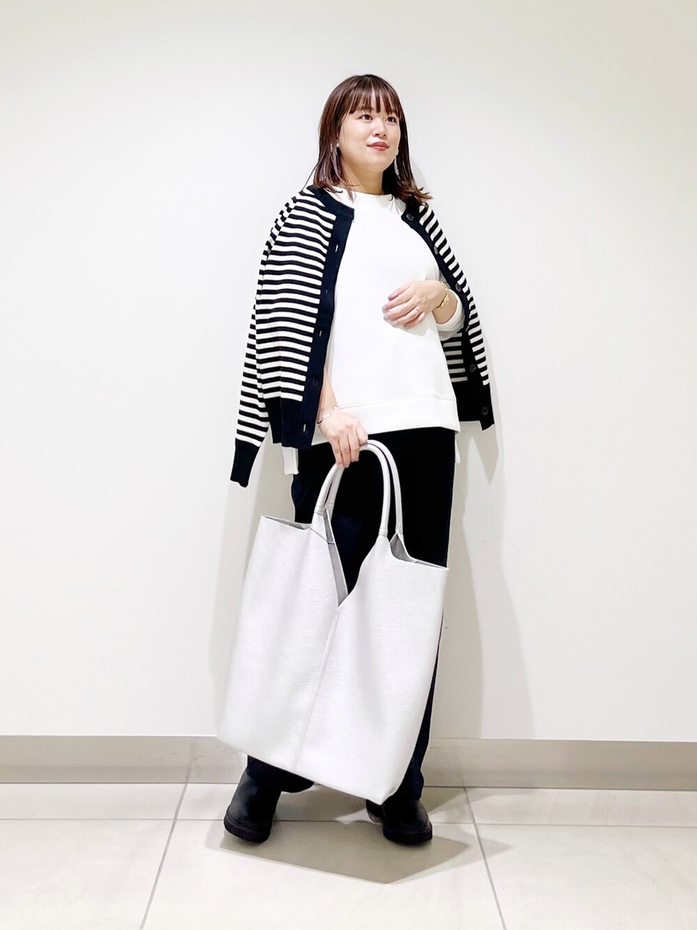 ホワイト系のTシャツ/カットソー、ブラック系のカーディガン/ボレロ、ブルー系のその他パンツを着用したレディースの秋コーディネートの6枚目の写真