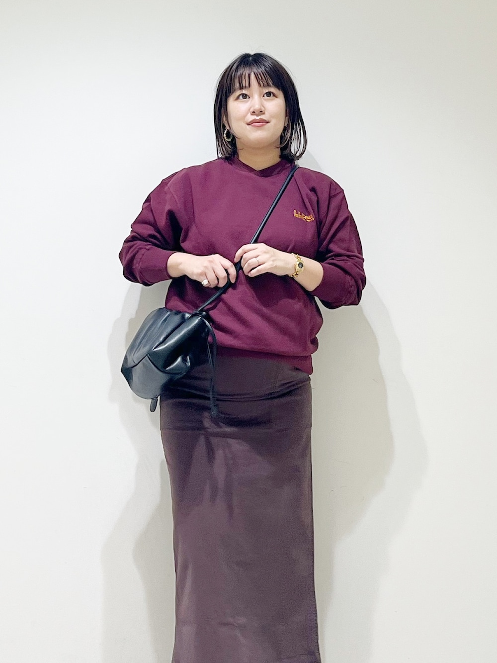 ブラウン系のスウェット、ブラウン系のスカート、ブラック系のスニーカーを着用したレディースの秋コーディネートの5枚目の写真