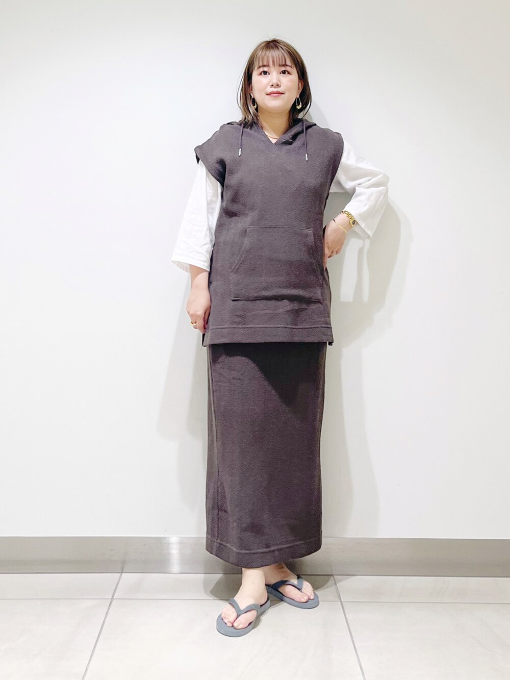 ブラウン系のパーカー、ブラウン系のスカート、グレー系のサンダルを着用したレディースの春コーディネートの5枚目の写真