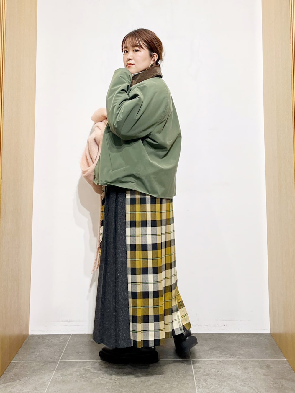 グリーン系のその他アウター、ベージュ系のニット/セーター、ベージュ系のスカートを着用したレディースの秋コーディネートの2枚目の写真