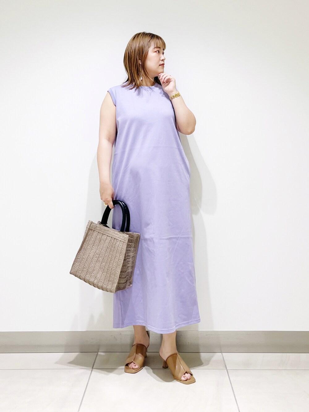 パープル系のワンピース、ベージュ系のトートバッグ、ベージュ系のサンダルを着用したレディースの夏コーディネートの4枚目の写真