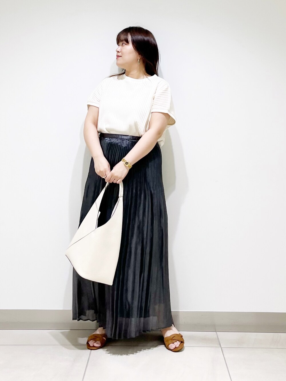 ブラック系のスカート、ホワイト系のニット/セーター、ホワイト系のトートバッグを着用したレディースの夏コーディネートの6枚目の写真