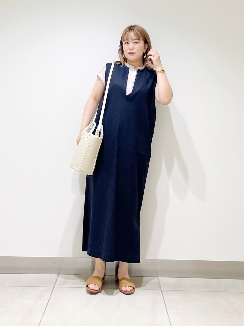 ブラック系のワンピース、ベージュ系のショルダーバッグ、イエロー系のサンダルを着用したレディースの夏コーディネートの5枚目の写真