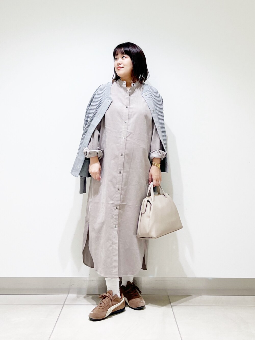 ベージュ系のワンピース、グレー系のカーディガン/ボレロ、グレー系のボストンバッグを着用したレディースの秋コーディネートの9枚目の写真