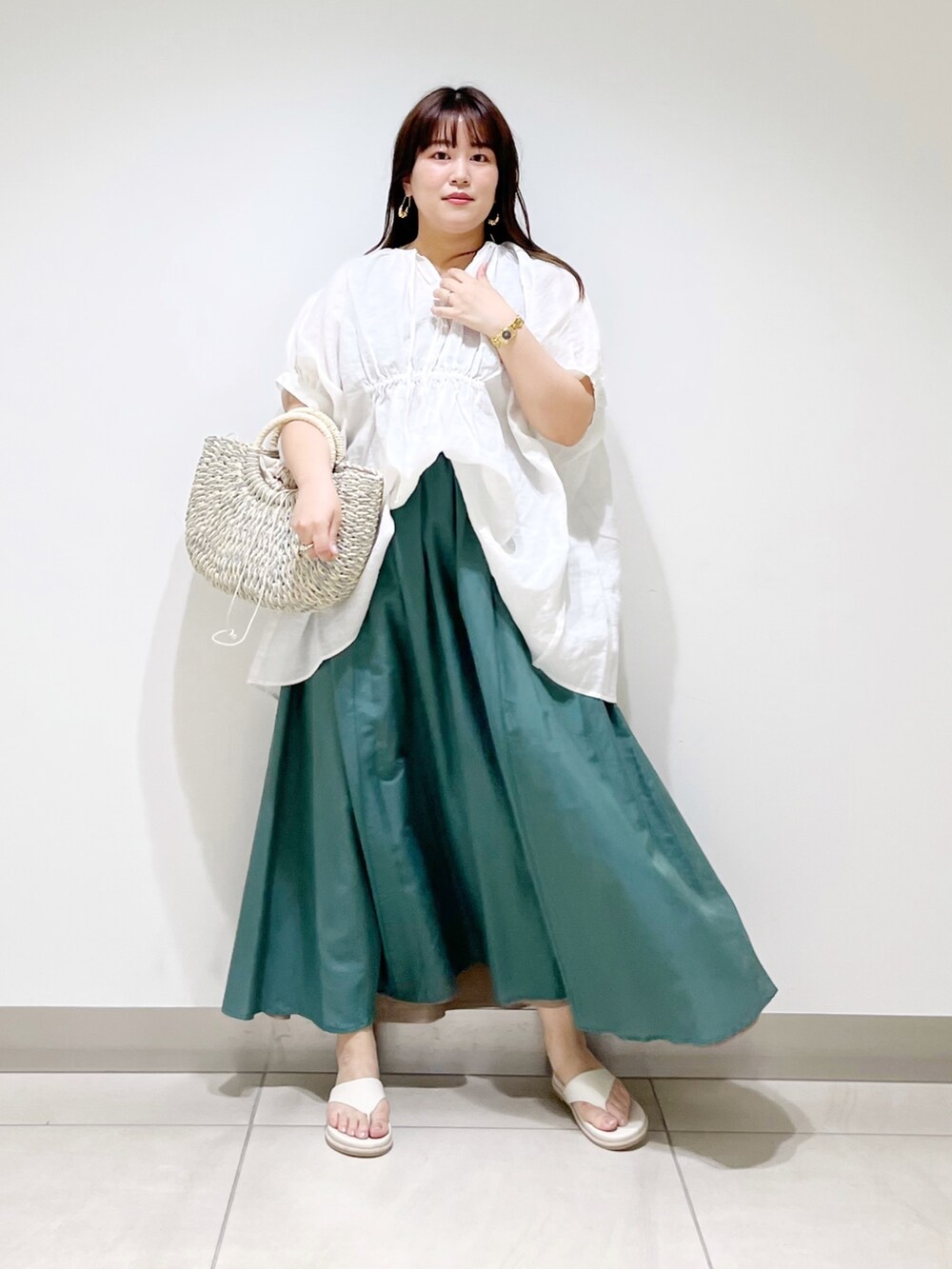 ホワイト系のシャツ/ブラウス、グリーン系のスカート、グレー系のかごバッグを着用したレディースの夏コーディネートの8枚目の写真